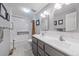 Bright bathroom with a double vanity, marble tiling, and a shower-tub combination at 8116 W Fremont Dr, Littleton, CO 80128