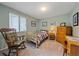 Comfortable bedroom with a rocking chair, blinds, and wood furnishings at 8116 W Fremont Dr, Littleton, CO 80128