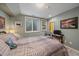 Cozy bedroom showcases a comfortable bed, side table, TV and basement egress window for ample light at 8116 W Fremont Dr, Littleton, CO 80128