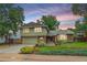 Charming two-story home with green siding, brick accents, a two-car garage, and manicured landscaping at 8116 W Fremont Dr, Littleton, CO 80128
