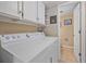 Functional laundry room with a full-size washing machine and dryer, plus convenient upper cabinet storage at 8116 W Fremont Dr, Littleton, CO 80128