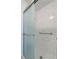 Modern walk-in shower features a glass door, marble tiling, and sleek grab bars at 8116 W Fremont Dr, Littleton, CO 80128