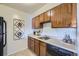 Functional kitchen with wood cabinets, a clean countertop, and modern appliances for efficient meal preparation at 5995 W Hampden Ave # 17F, Denver, CO 80227