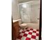Bathroom featuring a shower with swan-themed glass door, and red and white checkered floor at 267 S 3Rd Ave, Brighton, CO 80601