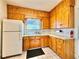 Functional kitchen with wood cabinetry and a classic white refrigerator at 267 S 3Rd Ave, Brighton, CO 80601