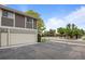 Exterior view of home's garage and parking area, with a pool and pergola visible in the background at 1250 S Monaco Pkwy # 50, Denver, CO 80224