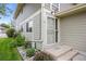Close-up of the front entrance featuring a secure white security door and well-maintained landscaping at 1250 S Monaco Pkwy # 50, Denver, CO 80224