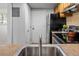Close-up of the kitchen sink with view of the refrigerator and stove at 1250 S Monaco Pkwy # 50, Denver, CO 80224