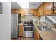 Well-equipped kitchen with stainless steel appliances, wooden cabinets, and a functional layout for cooking at 1250 S Monaco Pkwy # 50, Denver, CO 80224