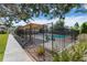 Community pool enclosed by a black fence, featuring a wooden pergola and landscaping at 1250 S Monaco Pkwy # 50, Denver, CO 80224