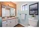 Bright bathroom featuring wood accent wall, granite vanity, a toilet, and a shower with tub at 4681 S Decatur St # 327, Englewood, CO 80110