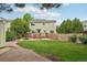 Spacious backyard featuring a wooden deck, lush lawn, mature trees, and a privacy fence at 2427 Cherry Cir, Brighton, CO 80601