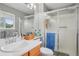 Bright bathroom features a shower with sliding glass doors, modern vanity, and natural light from the window at 2427 Cherry Cir, Brighton, CO 80601