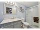 Updated bathroom with a gray vanity, marble countertop, framed mirror, and glass shower doors at 2427 Cherry Cir, Brighton, CO 80601
