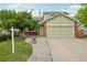 Inviting two-story home featuring lush green lawn, mature tree, and well-kept yard at 2427 Cherry Cir, Brighton, CO 80601