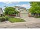 Charming two-story home with a well-manicured lawn, mature trees, and an attached two-car garage at 2427 Cherry Cir, Brighton, CO 80601