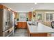 Well-equipped kitchen with stainless steel appliances, wood cabinets, quartz countertops, and a view to the backyard at 2427 Cherry Cir, Brighton, CO 80601