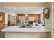 Open-concept kitchen with stainless steel appliances, light countertops, wood cabinetry, and a breakfast bar area at 2427 Cherry Cir, Brighton, CO 80601