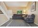 Cozy living room with comfortable seating, gray flooring and a window with backyard views at 2427 Cherry Cir, Brighton, CO 80601