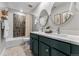 Charming bathroom featuring double vanity, oval mirrors, patterned floor tiles, and coordinated shower at 4334 Ridgewalk Pt, Castle Rock, CO 80108