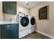 Efficient laundry room featuring modern appliances, cabinet storage, sink, and stylish floor tiles at 4334 Ridgewalk Pt, Castle Rock, CO 80108