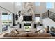 Open living room with sleek fireplace, hardwood floors, modern decor, and outdoor views at 4334 Ridgewalk Pt, Castle Rock, CO 80108