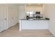 A well-lit kitchen featuring stainless steel appliances, white cabinetry, an island and light wood flooring at 14578 W 90Th Ln # B, Arvada, CO 80005