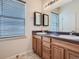 Bathroom with double sinks, modern vanity, a large mirror, and a window with blinds at 11250 Florence St # 20B, Commerce City, CO 80640