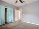 Bedroom features neutral carpet, a closet with curtains, and a ceiling fan at 11250 Florence St # 20B, Commerce City, CO 80640