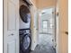 Convenient laundry area with stacked washer and dryer, leading to a carpeted room at 11250 Florence St # 20B, Commerce City, CO 80640