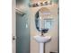 Contemporary powder room with pedestal sink, oval mirror, and modern lighting at 11250 Florence St # 20B, Commerce City, CO 80640