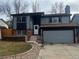 Charming two-story home with gray siding, brick accents, attached garage, and freshly landscaped front yard at 20328 E Powers Ln, Aurora, CO 80015