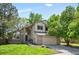 Charming two-story home with a well-manicured lawn, mature trees, and attached two car garage at 7582 Powderhorn Dr, Lone Tree, CO 80124