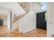 Bright foyer with wood floors, staircase, and black front door providing an inviting entrance at 7582 Powderhorn Dr, Lone Tree, CO 80124