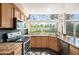 Charming kitchen features stone counters, stainless appliances, and a beautiful view from large windows at 7582 Powderhorn Dr, Lone Tree, CO 80124