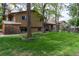 Spacious backyard with a lush green lawn, mature trees, and partial home view at 8793 E Monmouth Pl, Denver, CO 80237