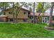 Expansive backyard featuring green lawn and mature trees surrounding the home at 8793 E Monmouth Pl, Denver, CO 80237