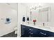 Bright bathroom featuring a double vanity with blue cabinets and modern fixtures at 8793 E Monmouth Pl, Denver, CO 80237