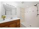 This bathroom features a white shower, tile floors, and a wood vanity at 8793 E Monmouth Pl, Denver, CO 80237