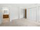 Bright bedroom with neutral carpet, white walls, and ample closet space at 8793 E Monmouth Pl, Denver, CO 80237