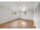 Spacious bedroom with hardwood floors, closet, and two bright windows at 8793 E Monmouth Pl, Denver, CO 80237