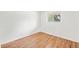 Bedroom featuring hardwood floors, white walls, and a window overlooking the yard at 8793 E Monmouth Pl, Denver, CO 80237