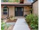 The front entrance features a solid dark door with decorative glass panes and beautiful, mature landscaping at 8793 E Monmouth Pl, Denver, CO 80237