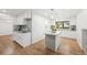 Modern kitchen featuring white cabinets, granite countertops, stainless steel appliances, and hardwood floors at 8793 E Monmouth Pl, Denver, CO 80237