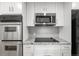 Updated kitchen features stainless steel appliances, granite counters, and white cabinets at 8793 E Monmouth Pl, Denver, CO 80237