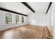 Bright living room featuring hardwood floors, dark wood beams, and large windows offering outdoor views at 8793 E Monmouth Pl, Denver, CO 80237