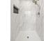 Tiled shower featuring marble walls, a built-in niche, and a rainfall shower head at 8793 E Monmouth Pl, Denver, CO 80237