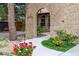 A stone walkway leads to the main entrance, framed by an arched brick walkway and vibrant floral landscaping at 8793 E Monmouth Pl, Denver, CO 80237