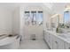 Bright bathroom featuring dual sinks, a soaking tub, and a large window with a view at 815 Gaylord St, Denver, CO 80206