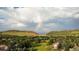 Scenic aerial view overlooking a rainbow, neighborhood, and mountains in the distance at 5 Catamount Ln, Littleton, CO 80127